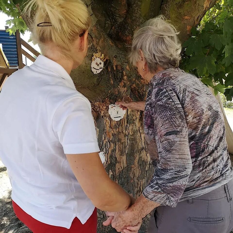 Pflegekraft hält Hand mit Klientin