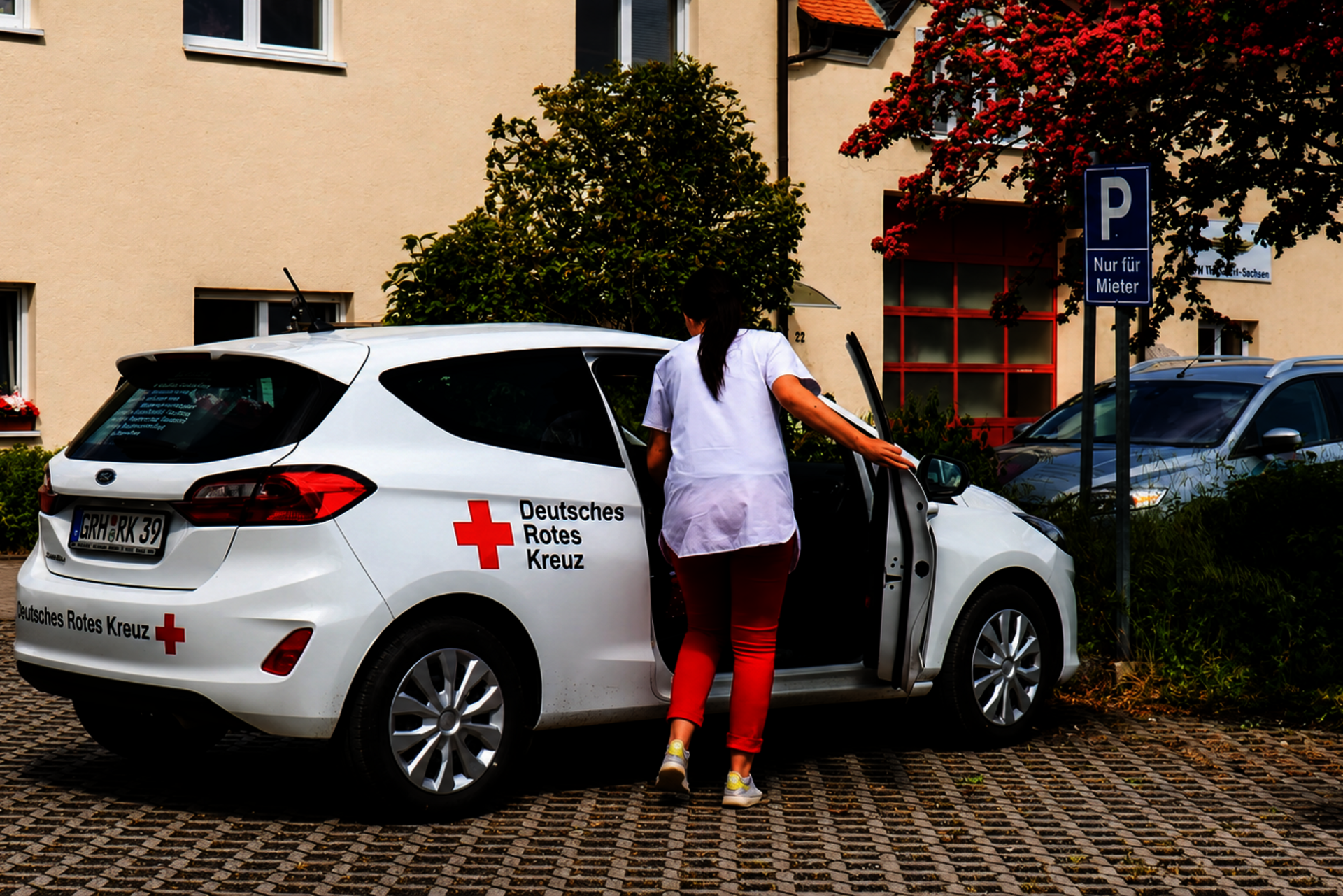 Schwester mit Dienstwagen